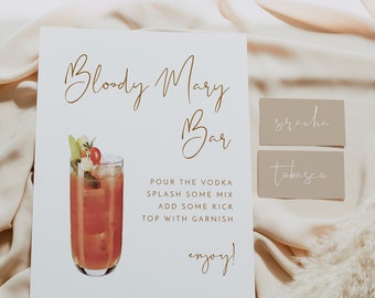 May include: A white sign with the text "Bloody Mary Bar" in gold script. The sign also includes a watercolor illustration of a Bloody Mary cocktail and instructions for making the drink. Two small brown signs with the text "siracha" and "tobasco" are also visible.