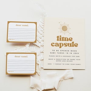 May include: Two gold-colored cards with white lines and the text "dear sami."  A larger card with a gold sun graphic and the text "time capsule" with instructions to be opened when Sami turns 18 in 20XX.  Write a message for Sami, make a prediction or share your hopes and wishes. Don't forget to sign your name.