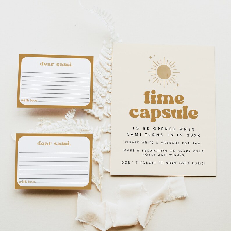 May include: Two gold-colored cards with white lines and the text "dear sami."  A larger card with a gold sun graphic and the text "time capsule" with instructions to be opened when Sami turns 18 in 20XX.  Write a message for Sami, make a prediction or share your hopes and wishes. Don't forget to sign your name.