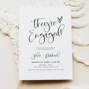May include: A white engagement announcement card with black script that reads "They're Engaged!" and details for the event. The card includes the names Jolie and Michael, the date, time, and location of the event, and RSVP information.