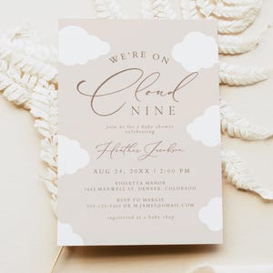 May include: A baby shower invitation with a light brown background and white clouds. The text reads "We're on Cloud Nine" with the words "Cloud Nine" in a cursive font. The invitation includes the date, time, location, and RSVP information.