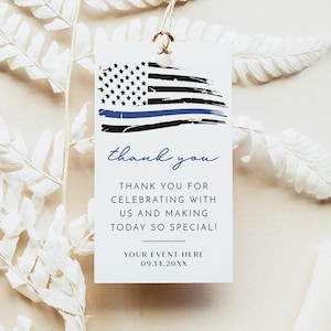 May include: A white gift tag with a distressed American flag design featuring a blue line. The tag includes the words "thank you" in cursive and the message "THANK YOU FOR CELEBRATING WITH US AND MAKING TODAY SO SPECIAL!" with a space for event details.