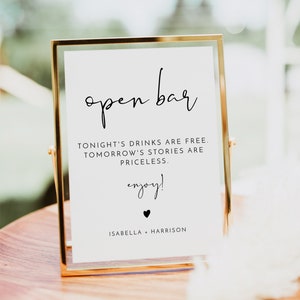 Peut inclure: Un panneau doré avec l'inscription "open bar" en écriture élégante. Le panneau comprend le texte "Tonight's drinks are free. Tomorrow's stories are priceless. Enjoy!" et les noms Isabella + Harrison.