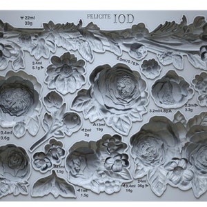 May include: A gray silicone mold with 13 different floral designs. The mold is labeled "FELICITE IOD" and includes measurements in milliliters and grams for each design.