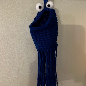 May include: Blue crocheted cookie monster hanging ornament with white googly eyes.