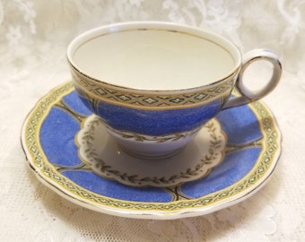 May include: A blue and gold teacup and saucer set with a floral design. The cup and saucer have a white background with a blue band and gold trim.