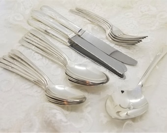 May include: A set of vintage silverware, including a butter knife, a serving spoon, and a set of forks and spoons. The silverware is made of polished silver and has an ornate design.