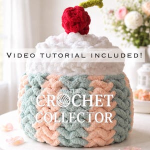 May include: A crochet cupcake-shaped container with a red cherry. The container is made with white, light blue, and peach yarn. The text on the container reads "THE CROCHET COLLECTOR" and "VIDEO TUTORIAL INCLUDED!"
