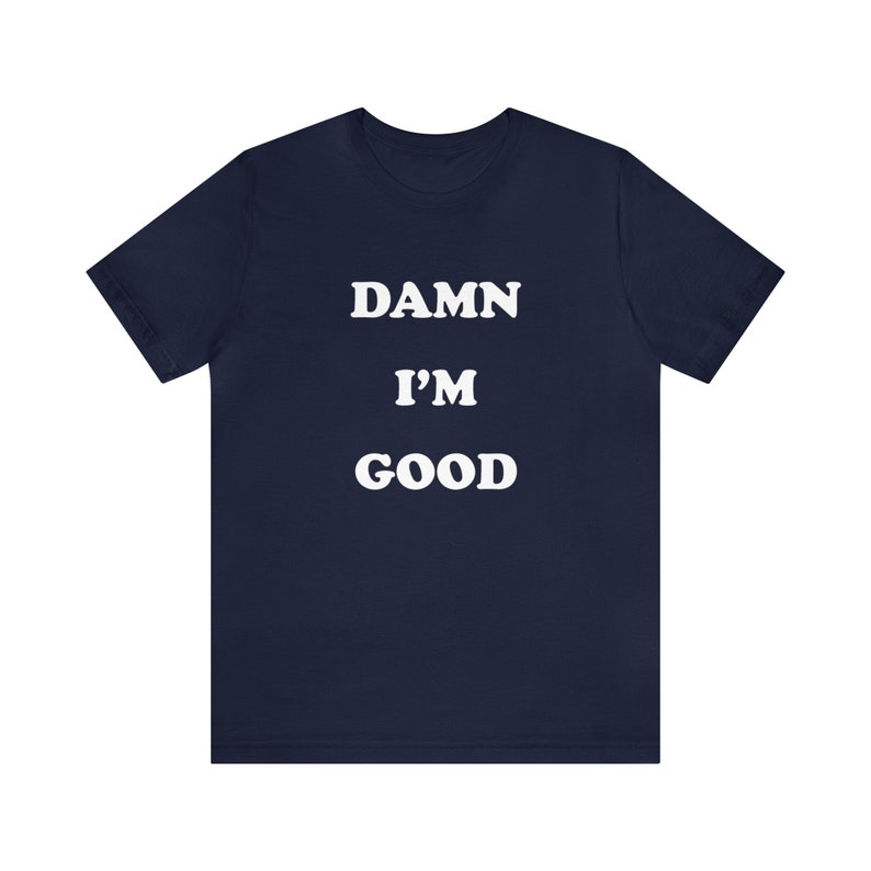 May include: Navy blue t-shirt with white text that reads "DAMN I'M GOOD".