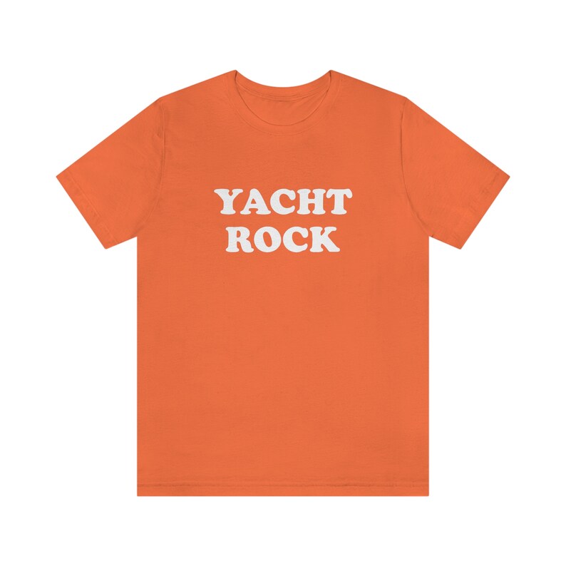 Puede incluir: Camiseta naranja de manga corta con el texto "YACHT ROCK" en blanco.