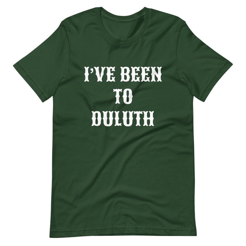 以下が含まれることがあります： 「I'VE BEEN TO DULUTH」という白い文字が書かれた濃い緑色のTシャツです。