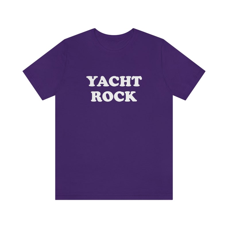 Puede incluir: Camiseta morada con el texto "YACHT ROCK" en blanco.