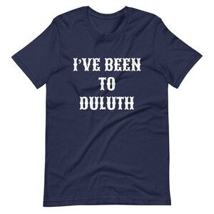 以下が含まれることがあります： 「I've Been To Duluth」という白い文字が書かれたネイビーのTシャツです。