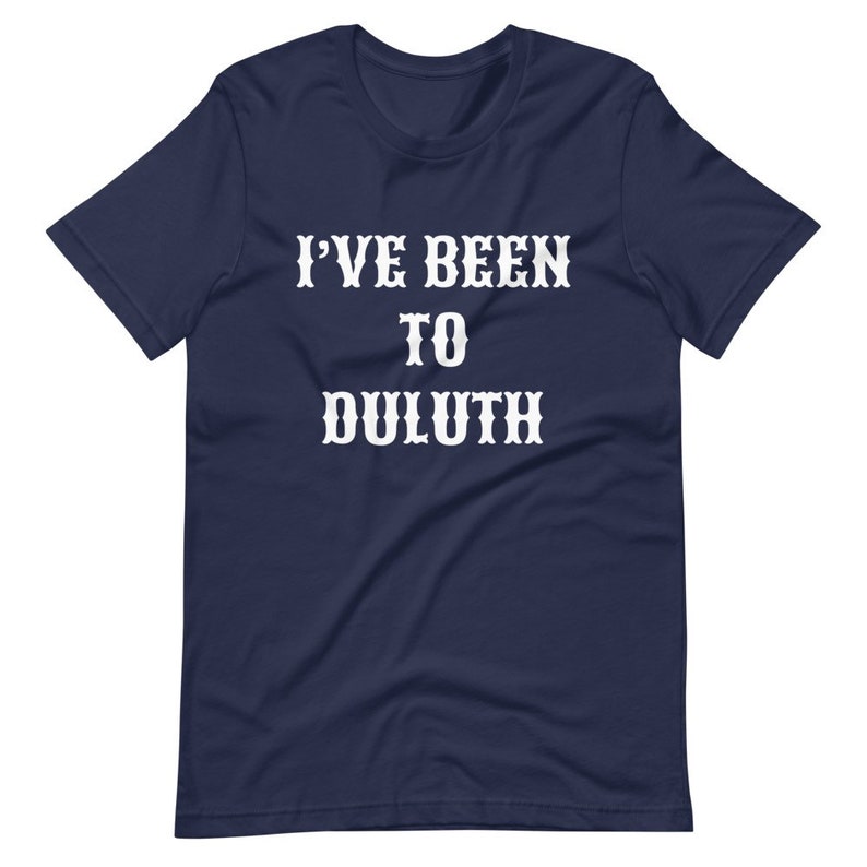 以下が含まれることがあります： 「I've Been To Duluth」という白い文字が書かれたネイビーのTシャツです。