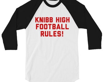 May include: A white and black baseball t-shirt with red text that reads "KNIBB HIGH FOOTBALL RULES!"