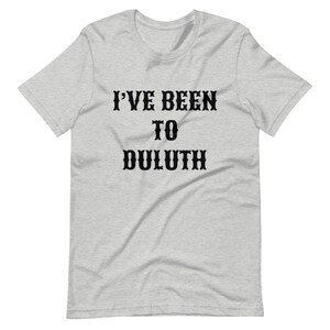 以下が含まれることがあります： グレーのTシャツに黒い文字で「I've Been To Duluth」と書かれています。