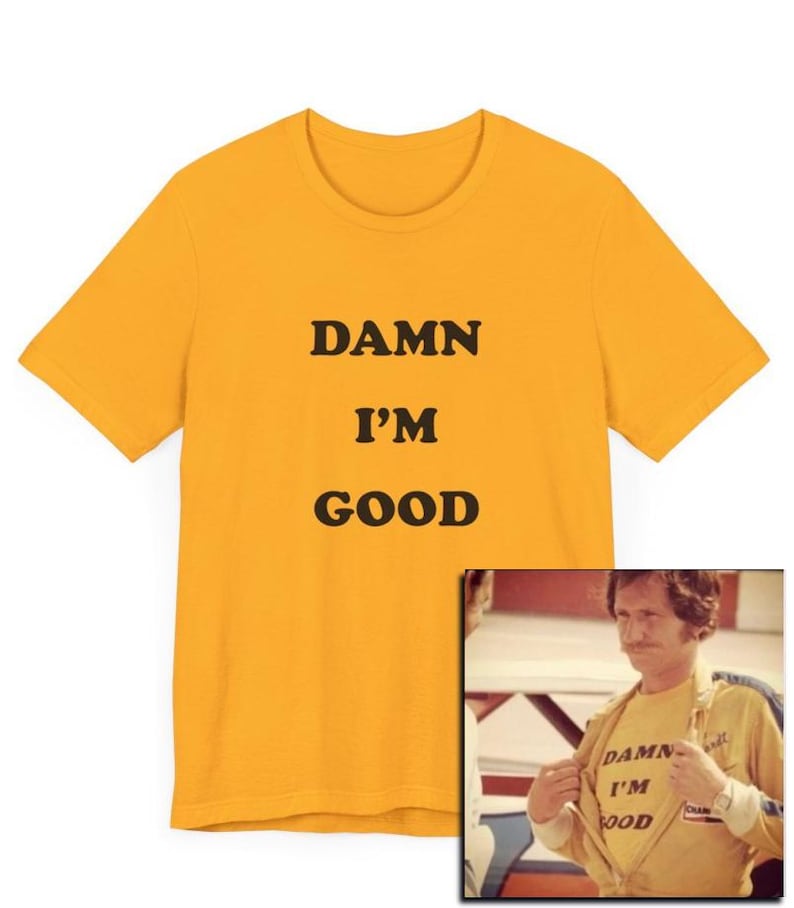 May include: A yellow t-shirt with the text "DAMN I'M GOOD" printed on it. The shirt is shown on a model wearing a similar shirt.