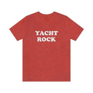 Puede incluir: Camiseta roja de punto con texto blanco que dice "YACHT ROCK".