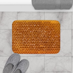 May include: A yellow honeycomb bath mat with a textured surface. The mat is on a tiled floor.