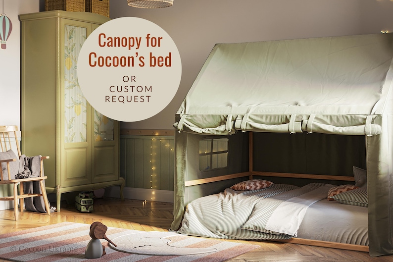 Puede incluir: Una tienda de campa&ntilde;a verde para una cama de ni&ntilde;o, con un marco de madera y un colch&oacute;n a rayas blancas. El texto "Canopy for Cocoon's bed OR CUSTOM REQUEST" es visible en la imagen.