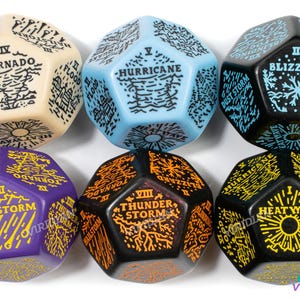 May include: Six black, blue, beige, purple, and orange dice with white and yellow text. Each die has a different weather-related word on each side, such as "Tornado", "Hailstorm", "Hurricane", "Blizzard", "Thunderstorm", and "Heat Wave".