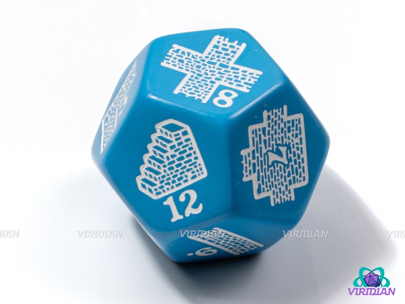 Op de afbeelding: Een blauwe 12-zijdige dobbelsteen met witte nummers en symbolen. De dobbelsteen heeft een bakstenen muurontwerp aan de ene kant en een trapontwerp aan de andere kant.