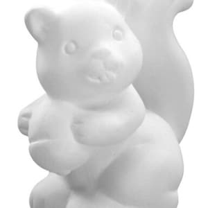 May include: White ceramic squirrel figurine holding a nut in its paws. The squirrel is sitting on its haunches with its tail curled up behind it.