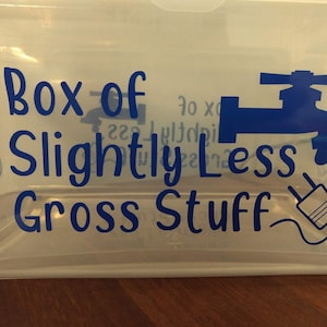 May include: A clear plastic storage box with a blue vinyl sticker that reads "Box of Slightly Less Gross Stuff". The sticker features a blue faucet and a blue electrical plug.