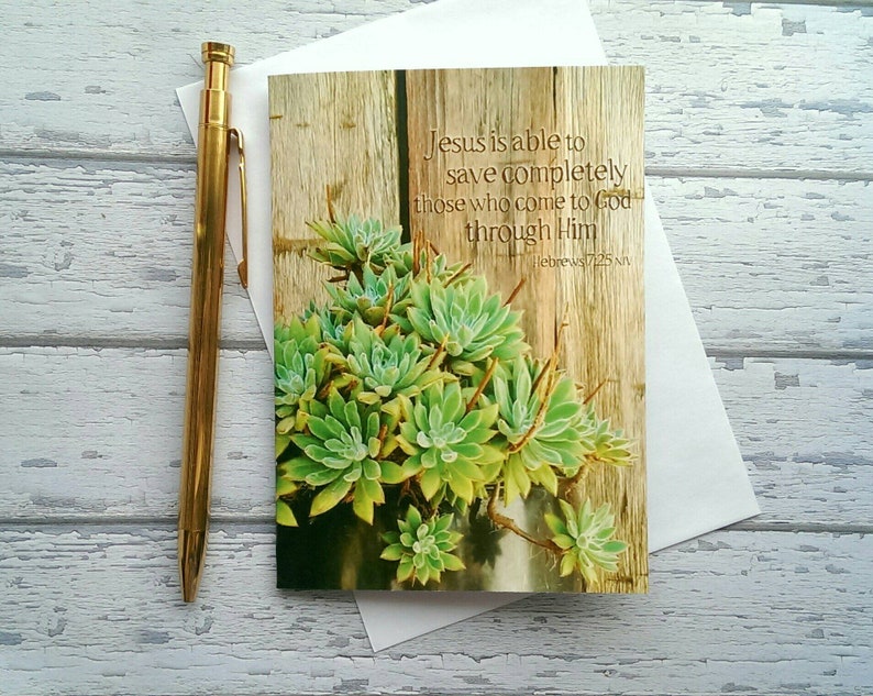 May include: A card with a wood background and a succulent plant. The card has a quote from Hebrews 7:25: "Jesus is able to save completely those who come to God through Him."