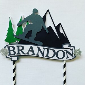 Snowboard cake topper with personalized name.