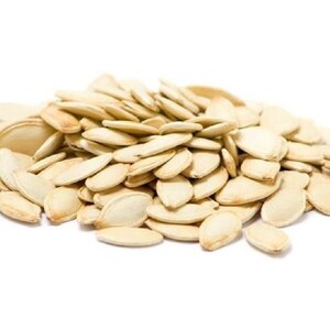 May include: A pile of light brown pumpkin seeds, a popular snack and ingredient.