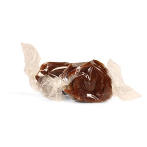 May include: Two brown caramel candies wrapped in clear cellophane.