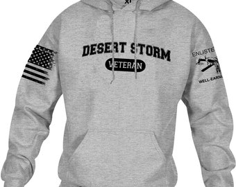 May include: A gray hoodie with a front pocket and drawstring hood. The front features the text "DESERT STORM VETERAN" in black. The left sleeve displays a distressed American flag, and the right sleeve has the text "ENLISTED WELL-EARNED" with a graphic.