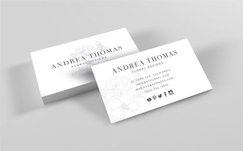May include: White business card with the text "ANDREA THOMAS FLORAL DESIGNS" and a floral design. The card also includes contact information, a website address, and social media icons.