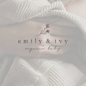 May include: A close-up of a baby wrapped in a white knitted blanket. The image features a logo with the text "emily & ivy organic baby" and a simple floral design.