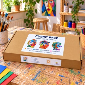 Może przedstawiać: Prostokątne brązowe pudełko kartonowe z etykietą Cubist Face Creative kit for children. Etykieta zawiera trzy kolorowe ilustracje abstrakcyjnych twarzy, tekst opisujący zawartość, przedział wiekowy 7-14 lat oraz małą flagę Litwy.