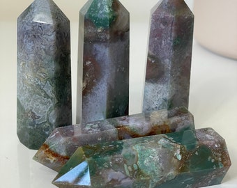 May include: Four green, brown, and white agate crystal points. The points are polished and have a smooth, glassy finish.