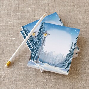 May include: A stack of blank notepads with a winter scene featuring a snowy forest and a lit street lamp. The scene is painted in shades of blue, white, and gray.