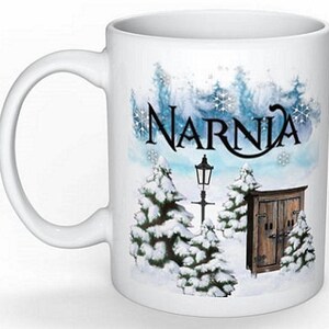 May include: White ceramic mug with a winter scene featuring snow-covered trees, a lamppost, and a wooden door. The text "Narnia" is printed in black on the mug.