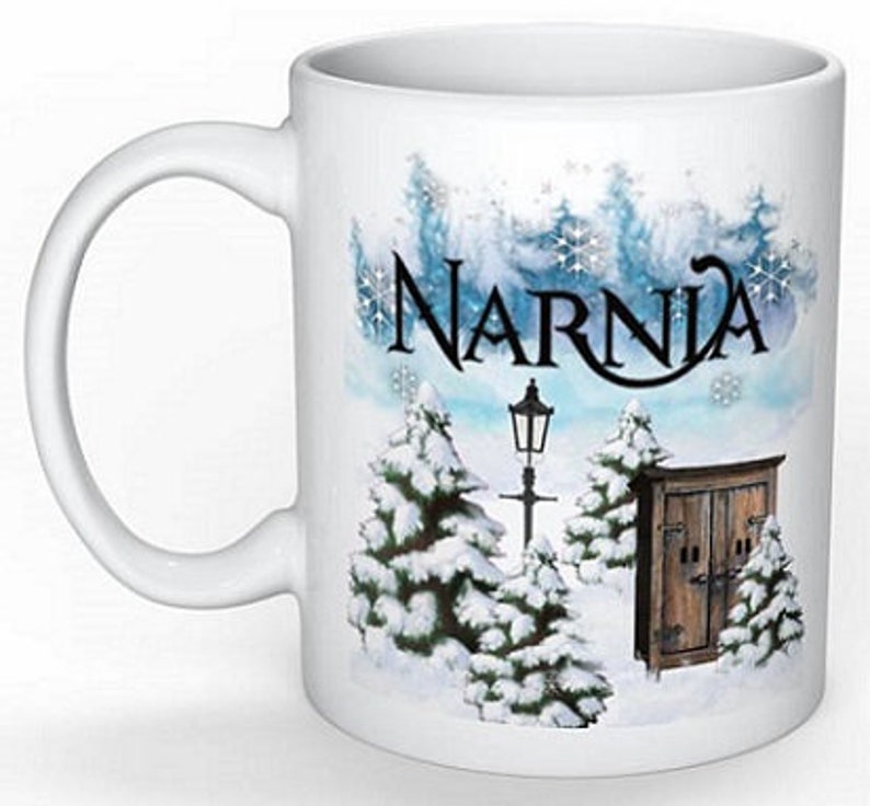 May include: White ceramic mug with a winter scene featuring snow-covered trees, a lamppost, and a wooden door. The text "Narnia" is printed in black on the mug.