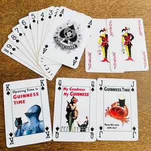 May include: A collection of playing cards featuring a Guinness theme. The cards include various suits, face cards, and jokers. Some cards have illustrations and text like "Opening Time is GUINNESS TIME" and "My Goodness My GUINNESS".