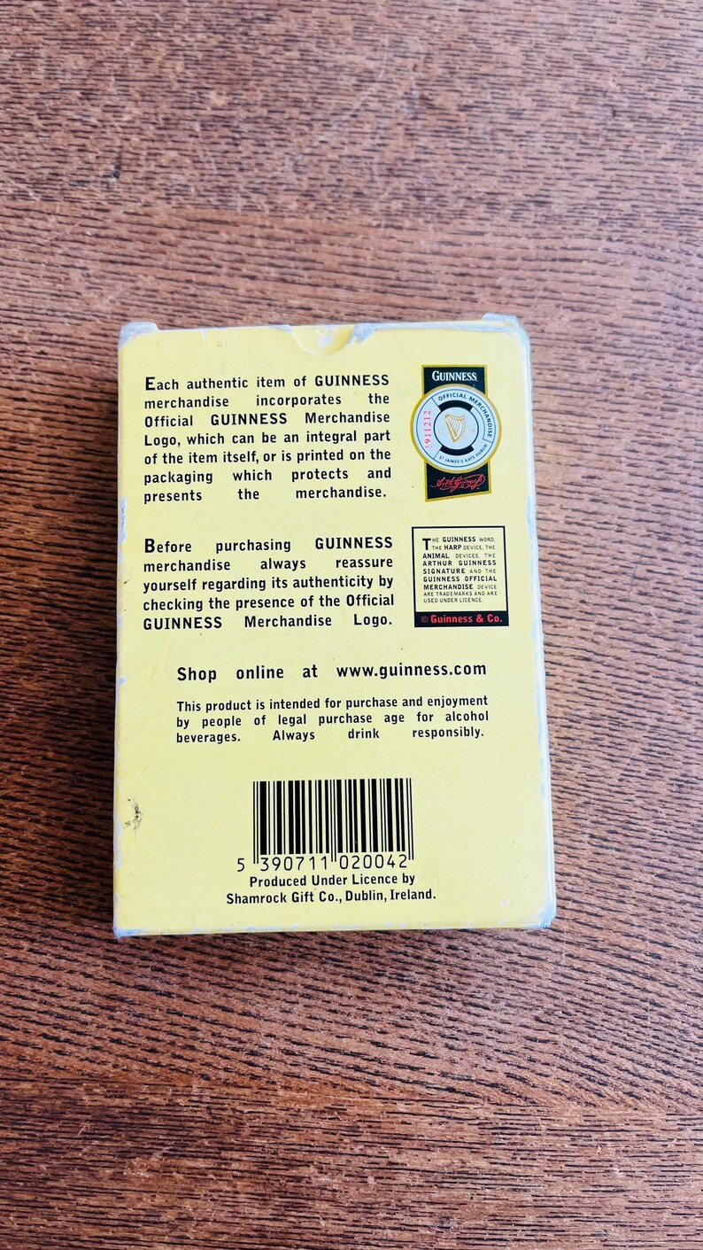 May include: A rectangular GUINNESS merchandise box with text and a logo. The box is yellow and black, with the GUINNESS logo in the upper right corner. The text describes the authenticity of the merchandise.