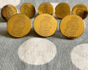 May include: A set of eight round gold-colored metal buttons. Each button features an embossed heraldic crest with a crown at the top and a banner at the bottom containing the text HONI SOIT QUI MAL Y PENSE and SUA TELA TONANTI.