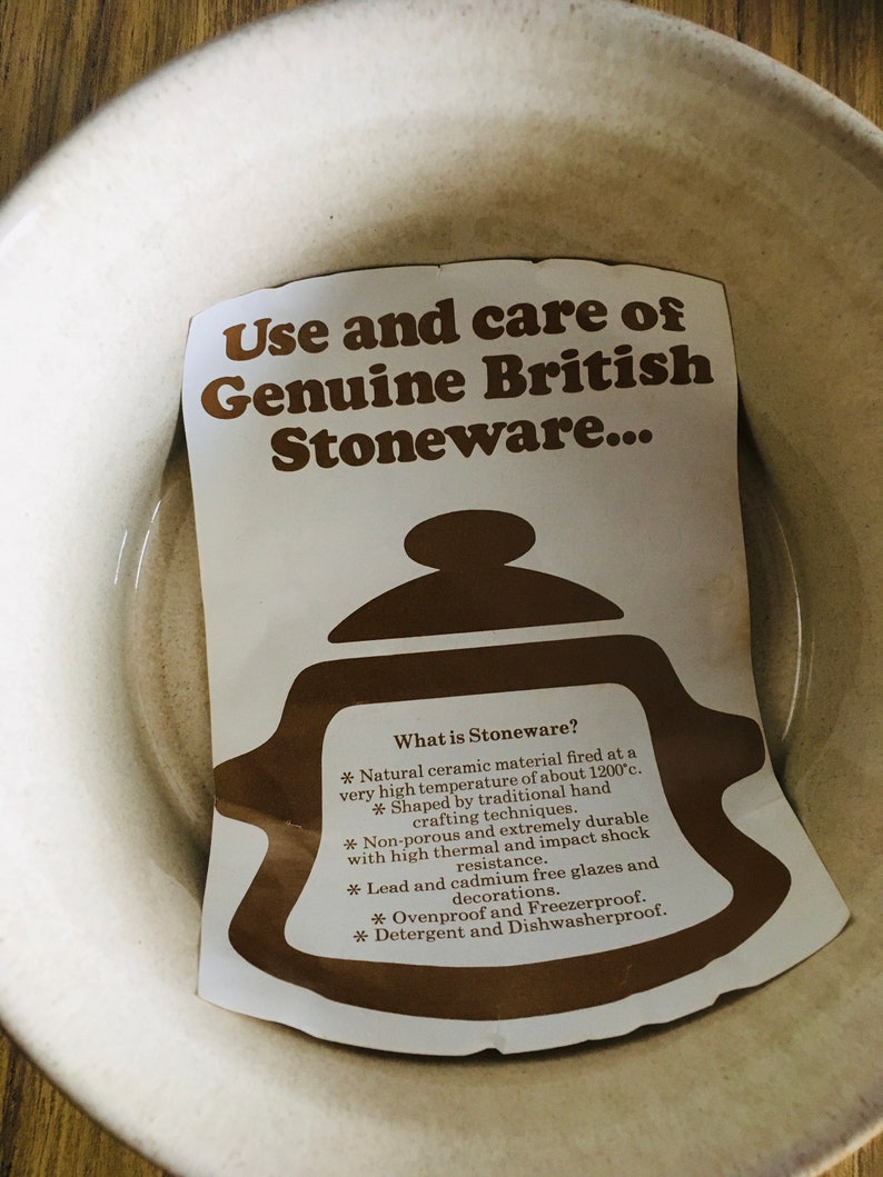 May include: A white card with brown text explaining the use and care of genuine British stoneware. The card features a brown illustration of a teapot. The text reads: "Use and care of Genuine British Stoneware... What is Stoneware? * Natural ceramic material fired at a very high temperature of about 1200&deg;c. * Shaped by traditional hand crafting techniques. * Non-porous and extremely durable with high thermal and impact shock resistance. * Lead and cadmium free glazes and decorations. * Ovenproof and Freezerproof. * Detergent and Dishwasherproof."