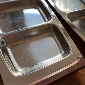 May include: A silver serving tray with four rectangular compartments, each with a slightly raised edge. The tray has a wooden frame.