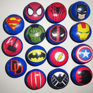 May include: Set of 15 round blue and white superhero themed knobs with various characters including Superman, Batman, Spiderman, Hulk, Iron Man, Captain America, Flash, and more.