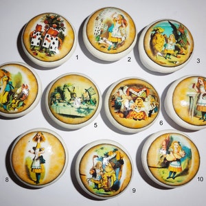 May include: Ten round ceramic knobs featuring images from Alice in Wonderland. The knobs depict scenes from the book, including Alice with the Mad Hatter, the Queen of Hearts, and the Cheshire Cat.