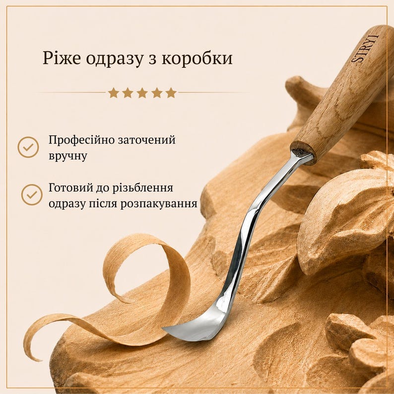 Peut inclure: Un outil de sculpture sur bois en m&eacute;tal avec une lame incurv&eacute;e et un manche en bois clair portant l'inscription STRYI. L'outil est pos&eacute; sur une pi&egrave;ce de bois sculpt&eacute; avec un copeau. Le texte sur l'image comprend des phrases en ukrainien.