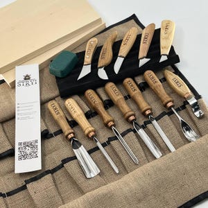 Könnte beinhalten: Handgefertigtes Holzschild mit dem Wort "Welcome" in verspielter Schrift. Es hat einen weißen, abgenutzten Hintergrund und einen dunkelbraunen Rahmen, geeignet für den Innen- und Außenbereich.