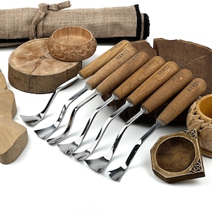 Peut inclure: Un ensemble de six outils de sculpture sur bois en m&eacute;tal avec des manches en bois brun clair, chacun marqu&eacute; du texte STRYI. Les outils pr&eacute;sentent des lames m&eacute;talliques polies et incurv&eacute;es, dispos&eacute;s avec des bols et blocs en bois.